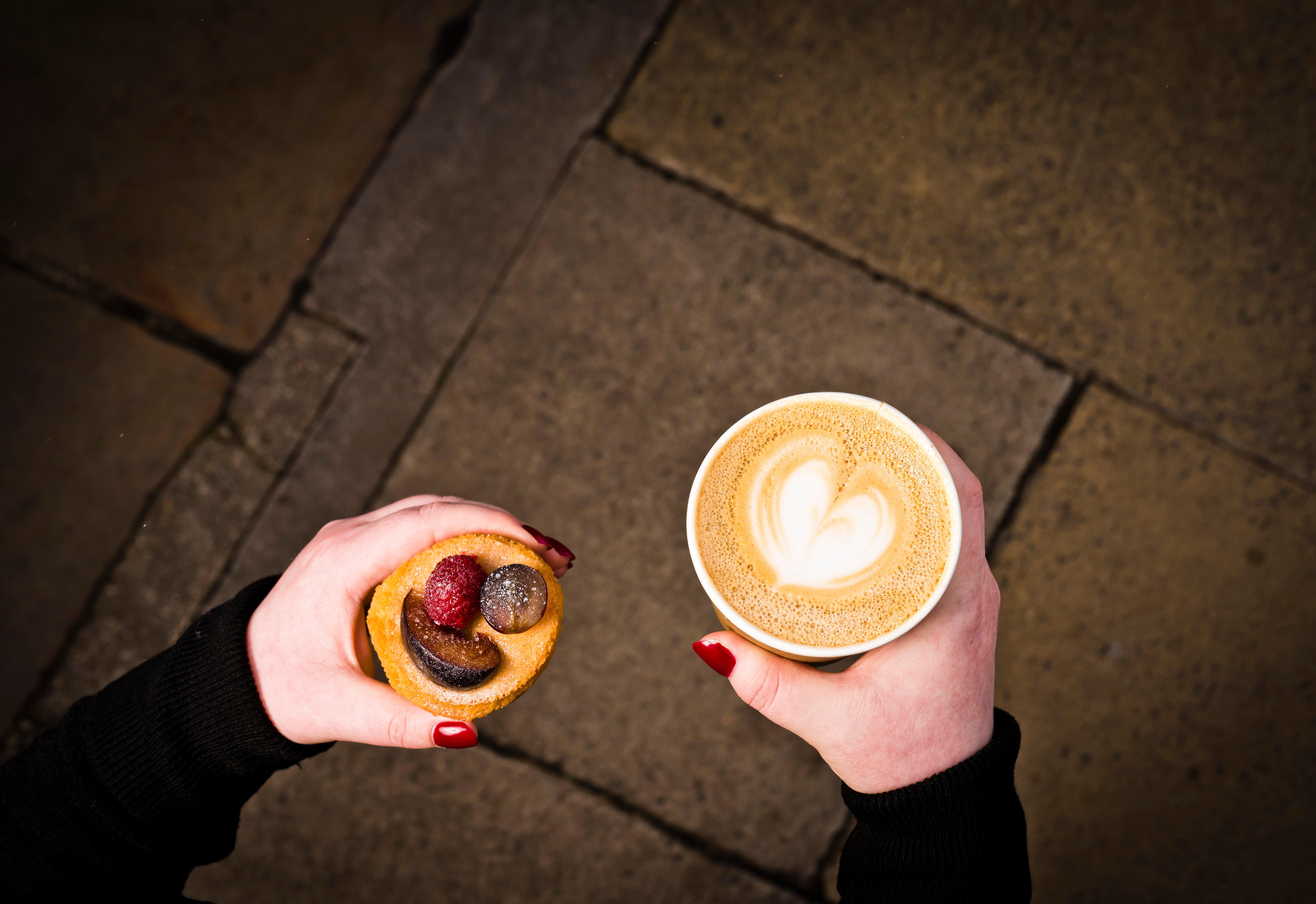 فندق إنتركونتيننتال إدنبرة ذا جورج المظهر الخارجي الصورة A woman holding a coffee and a doughnut